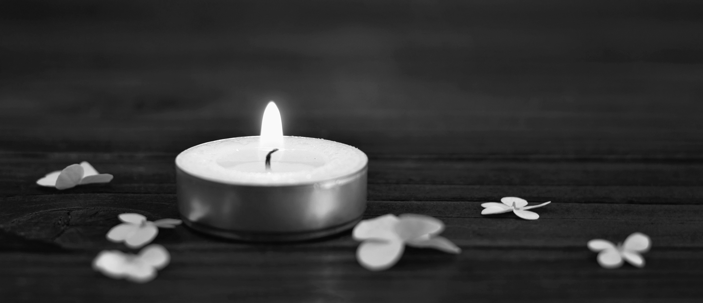 A candle with a flame and a flower