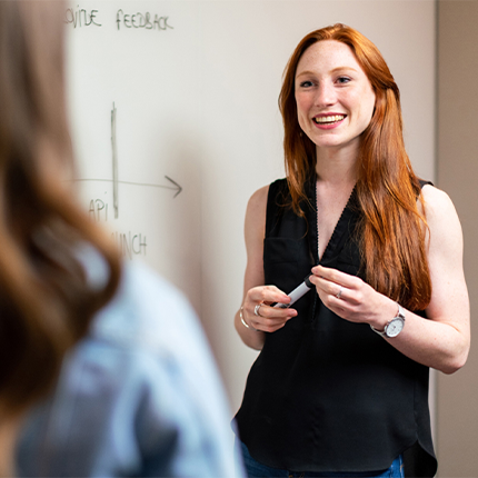 A woman standing in front of a whiteboard