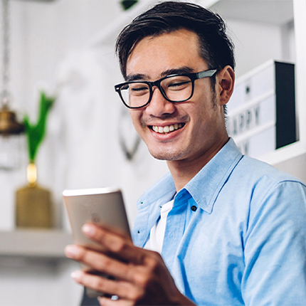 A man smiling while holding a phone