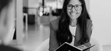 A woman smiling in a work meeting. 