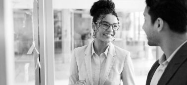 A woman smiles to a man in an office.
