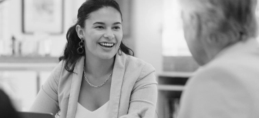 A woman smiling in a work meeting.