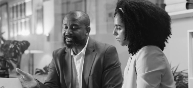 A man and a woman in a work meeting.