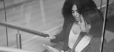 Two women chatting in an office.