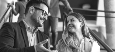 A man and a woman smiling in an office. 
