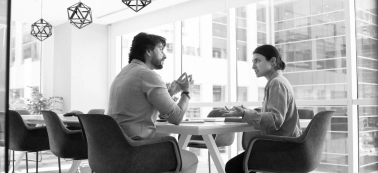 A man and a woman in a work meeting.
