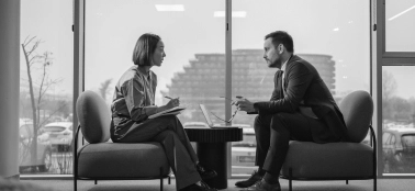 A man and a woman chatting in an office. 