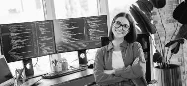 A woman in an office smiling at camera.
