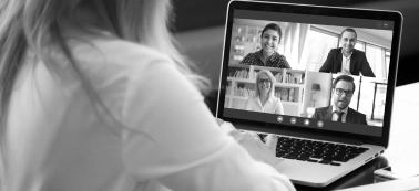 A woman with a laptop during a virtual meeting. 