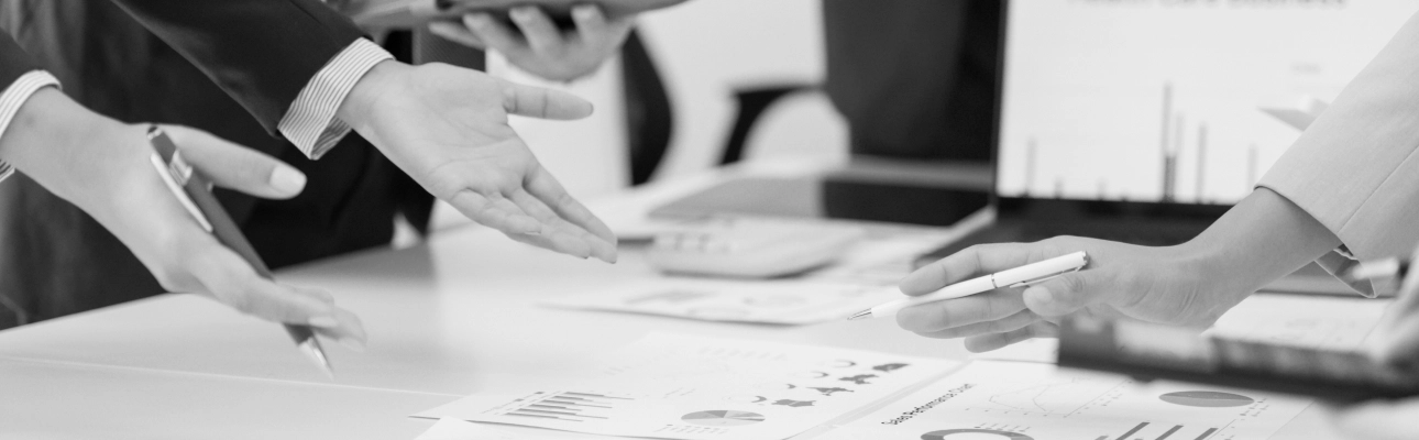 In the frame we see hands pointing out documents on a table.