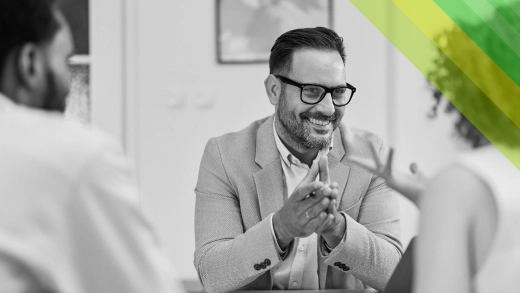 A man smiling during a work meeting. 