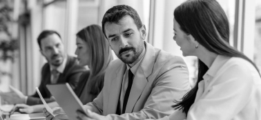 A man and a woman chatting in a work meeting.