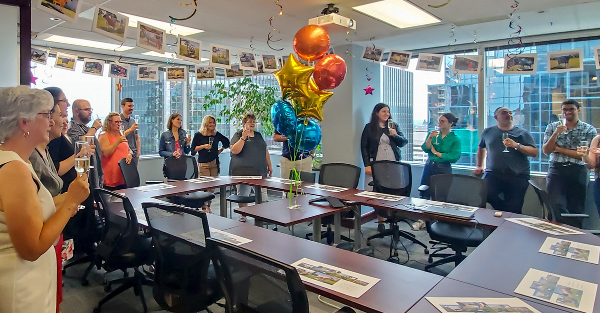 CIA staff gathered in an office with balloons and refreshments to celebrate Lynn Blackburn's 30th anniversary (2022).